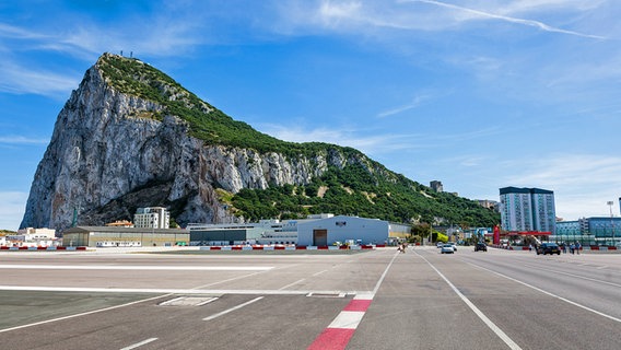 Verkehr auf der Hauptstraße Gibraltars. Die Straße fungiert nicht nur als Autoverkehr, sondern auch als Start- und Landebahn für Flugzeuge. Im Hintergrund ist der Fels von Gibraltar zu sehen (18.04.2022). © picture alliance / pressefoto_korb Foto: Micha Korb