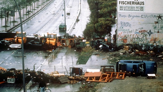 Straßenbarrikaden in der Hafenstraße in Hamburg am 18.11.1987. Die jahrelangen Auseinanderstzungen um die von einer bunten Szene junger Leute bewohnten, teilweise besetzten Häuser in der Hamburger Hafenstraße ist am 19.11.1987 durch einen Pachtvertrag für die Bewohner friedlich beigelegt worden. © picture-alliance/ dpa 