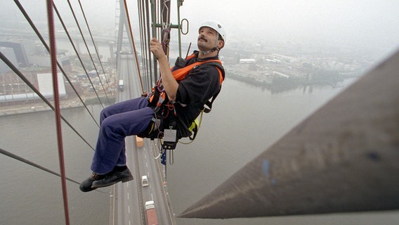 Martin Boldt überprüft 120 Meter über dem Hamburger Hafen am 29.09.1998, in einem Bootsmannstuhl hängend, die Tragseile der Köhlbrandbrücke. © picture-alliance / dpa Foto: Kay Nietfeld