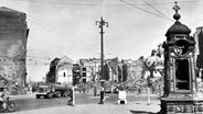 Ein Lkw fährt in Hannover aus der Georgstraße kommend an der zerstörten Kröpcke-Uhr vorbei. (1945) © picture alliance/dpa/Historisches Museum Hannover 