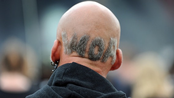 Ein Wacken-Festivalbesucher hat sich das "WOA"-Zeichen in die restlichen Haare am Hinterkopf rasiert (2. August 2012) © picture alliance / dpa Foto: Daniel Reinhardt