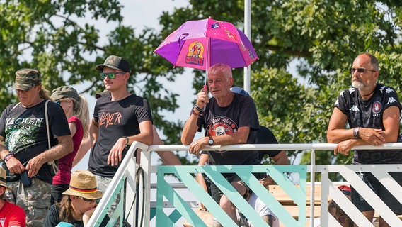 Ein Metal-Fan mit einem außergewöhnlichen Sonnenschutz auf dem Wacken Open Air, Festival am 4. August 2022 © picture alliance / Eibner-Pressefoto Foto: Eibner Pressefoto/Marcel von Fehrn