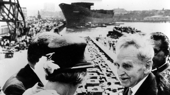 Nobelpreisträger Otto Hahn (r.) ist am 13. Juni 1964 dabei, als Europas erster atomar angetriebener Frachter, der den Namen des Chemikers trägt, in Kiel vom Stapel läuft. © picture alliance / ASSOCIATED PRESS 