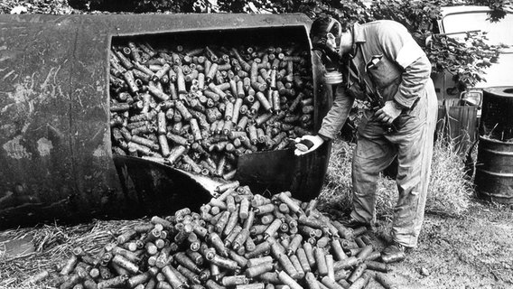 Ein Sprengstoffexperte steht in Hamburg vor großen Mengen Nebeltöpfen (Archivfoto vom 06.09.1979). © picture-alliance / dpa/dpaweb Foto: Werner Baum