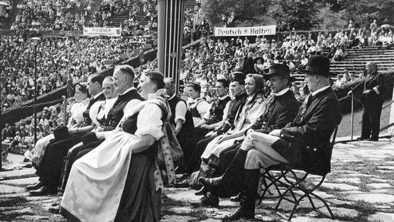 Eine Gruppe Schlesier in der Waldbühne in Berlin. Aufnahme vom 03.08.1952. In der Berliner Waldbühne veranstaltete der Bund der Heimatvertriebenen aus Anlass des Tages der Heimat eine Kundgebung zu der mehr als 15.000 Menschen aus den Ostgebieten kamen. © picture alliance / dpa Foto: dpa-Fotografen