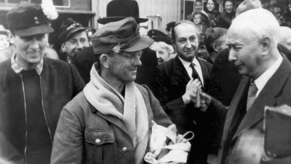 Am 18. Oktober 1955 begrüßt Theodor Heuss die aus der der Sowjetunion heimgekehrten Zivilinternierte und ehemalige Soldaten im  Grenzdurchgangslager Friedland . © dpa - Bildfunk Foto: dpa