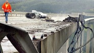 Ein beschädigter BMW steht an der Stelle, von der nach einem Zusammenstoß auf der A4 ein brennender Tanklastzug von der Wiehltalbrücke bei Gummersbach 100 Meter in die Tiefe stürzte (Archivfoto vom 26.08.2004). © picture-alliance/ dpa/dpaweb Foto: Jörg Carstensen