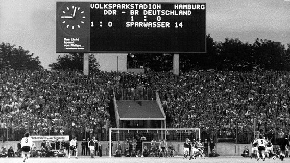 Von der Anzeigetafel im ausverkauften Hamburger Volksparkstadion leuchtet am 22.6.1974 im Weltmeisterschafts-Gruppenspiel Bundesrepublik - DDR der sensationelle Spielstand in der Schlußphase. Die DDR-Elf führt gegen die DFB-Mannschaft mit 1:0, und das ist auch der Endstand - eine der größten Fußballsensationen in der WM-Geschichte. © picture-alliance / dpa 