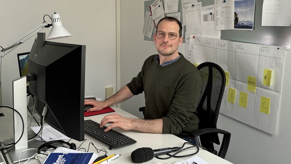 Ein Mann mit kurzen Haaren und Drei-Tage-Bart sitzt vor einem Computer und blickt in die Kamera. © NDR.de Foto: Ulrike Hummel