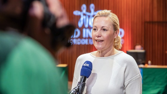 Bettina Wulff beim Spendentag "Hand in Hand für Norddeutschland" mit einem Schild im Interview. © Axel Herzig Foto: Axel Herzig