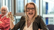 Jane Comerford sitzt lächelnd am Spendentelefon von Hand in Hand für Norddeutschland © NDR Foto: Janis Roehlig