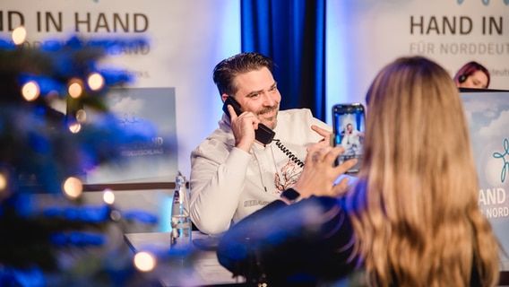 Sebastian Hämer im Call-Center am Spendentelefon bei der Benefizaktion "Hand in Hand für Norddeutschland" im NDR Landesfunkhaus in Mecklenburg-Vorpommern. © NDR Foto: Katharina Kleinke