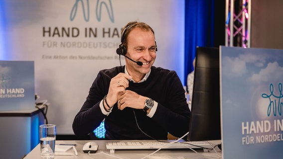 Der Fußballschiedsrichter Bastian Dankert hat sichtlich Spaß am Telefon. © NDR Foto: Katharina Kleinke