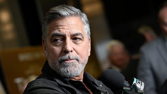 Der US-Schauspieler George Clooney schaut bei einerm Pressetermin zum Film "The Boys in the Boat" im Dezember 2023 an der Kamera vorbei © picture alliance Foto: Evan Agostini