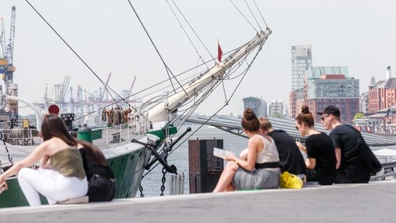 Junge Leute sitzen am Hamburger Hafen auf den Stufen. (Symbolbild) © picture alliance Foto: Markus Scholz