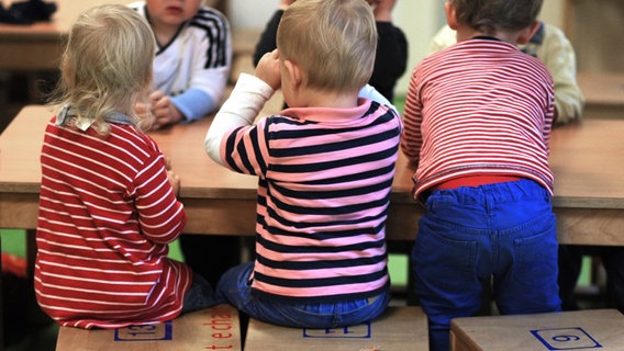 Eine Gruppe von Kindern im Kindergarten sitzt an einem Tisch © picture alliance Foto: Julian Stratenschulte