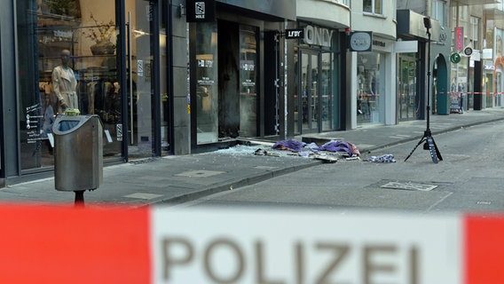 Scherben und Kleidungstücke liegen vor einem Geschäft in der Ehrenstraße in Köln. © picture alliance / dpa Foto: Henning Kaiser