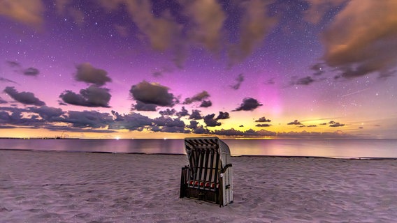 Ein Strandkorb am Strand von Prerow mit Langzeitbelichtung vor einem Sternenhimmel. © NDR Foto: Klaus Haase aus dem Ostseebad Prerow