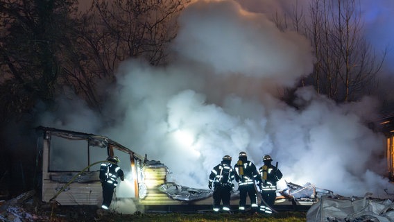 Feuerwehrleute löschen ein brennendes Mobilheim. © JOTO Foto: Tobias Johanning