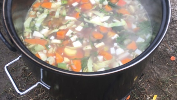 Gemüsesuppe kocht in einem Ofenkocher im Projektgarten in Hunden in Niedersachsen. © Grundschule Binnenmarsch 