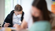 Zwei Schüler mit Schutzmasken sitzen im Klassenraum. (Themenbild) © picture alliance Foto: Jonas Güttler