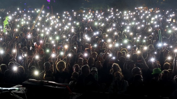 Beim Auftritt von Rapper Danger Dan am zweiten Festivaltag halten die Fans leuchtende Gegenstände in die Höhe © dpa 