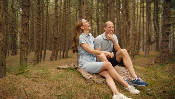 Kate Middleton und Prinz William sitzen im Wald auf einer Decke und lachen, Foto aus der Videobotschaft: Prinzessin Kate beendet Chemotherapie © Will Warr/Kensington Palace/PA Foto: Will Warr