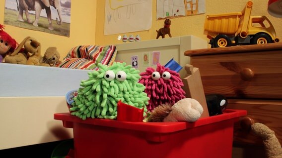 Folge 12. Kettenreaktion: Wisch & Mop mit großen Augen in der Spielzeugkiste © NDR Foto: Screenshot