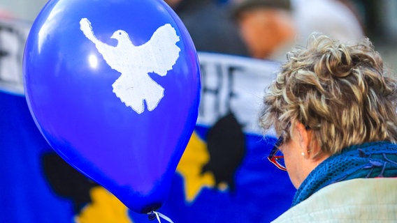 Ein blauer Luftballon mit dem Symbol einer weißen Friedenstaube © picture alliance / dpa Foto: Jens Wolf