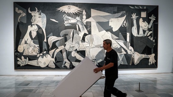 Ein Arbeiter passiert Pablo Picassos "Guernica" im Reina Museum in Madrid. © picture alliance / ASSOCIATED PRESS Foto: Andrea Comas