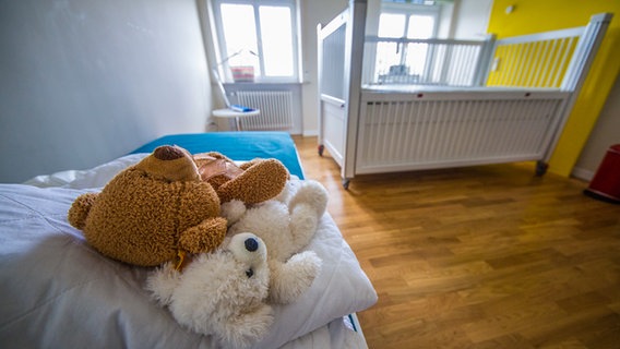 In einem Kinderhospiz liegen zwei Teddys auf einem Bett. © picture alliance Foto: Christoph Schmidt