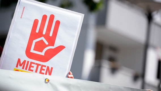 Jemand hält ein Plakat hoch - darauf ist eine rote Hand und der Schriftzug "Mieten" zu sehen. © picture alliance/dpa Foto: Jonas Walzberg