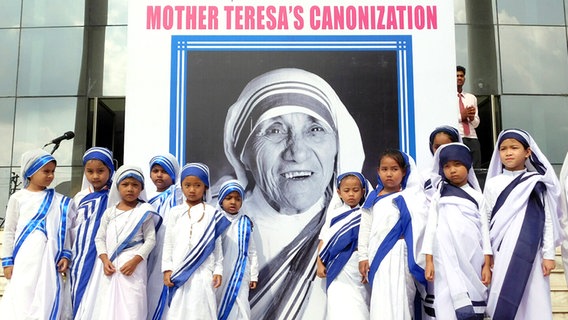 Schülerinnen posieren vor einem Porträt von Mutter Teresa. © picture alliance/ZUMA Press Foto: Stringer