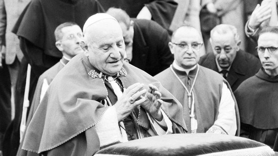 Papst Johannes XXIII. kniet nieder und betet. Im Hintergrund sind weitere Geistliche zu sehen (1961). © picture alliance / ASSOCIATED PRESS Foto: Mario Torrisi