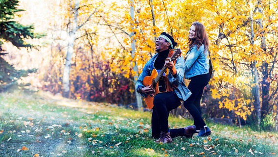 Ein junges Paar macht Musik im Wald. © picture alliance / Design Pics | LJM Photo 