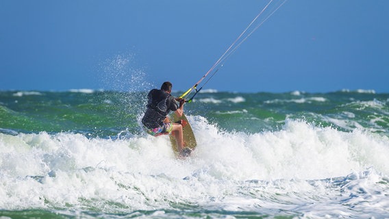 Ein Mann auf einem Kiteboard in der Brandung. © Colourbox Foto: Anna Moskvina