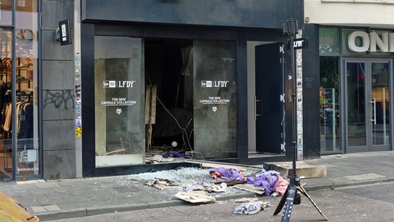 Scherben und Kleidungstücke liegen vor einem Geschäft in der Ehrenstraße in Köln. © picture alliance / dpa Foto: Henning Kaiser