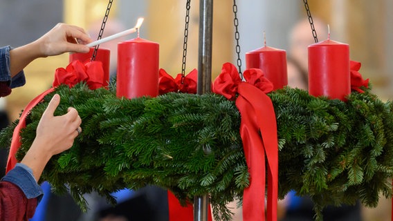 Hand zündet Adventskranz an © picture alliance / epd-bild | Daniel Peter Foto: Daniel Peter