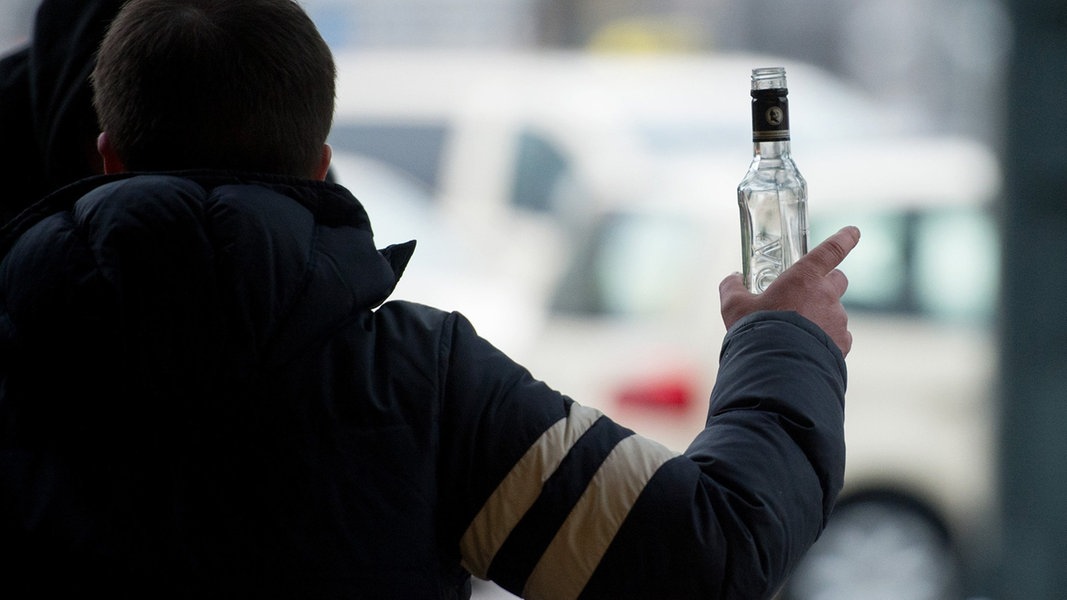 Ein stark alkoholisierter Mann gestikuliert am Hauptbahnhof mit einer Wodkaflasche in der Hand.