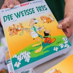 Ein Verkäufer hält den Band "Die weiße Iris" in den Händen. © picture alliance/dpa | Rolf Vennenbernd 