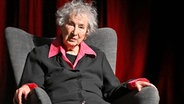 Eine ältere Frau mit weißen Haaren und roter Bluse sitzt in einem Sessel und schaut aufmerksam: Margaret Atwood, kanadische Schriftstellerin im November 2024 © Imago/TT Jonas Ekströmer/TT Foto: Jonas Ekströmer