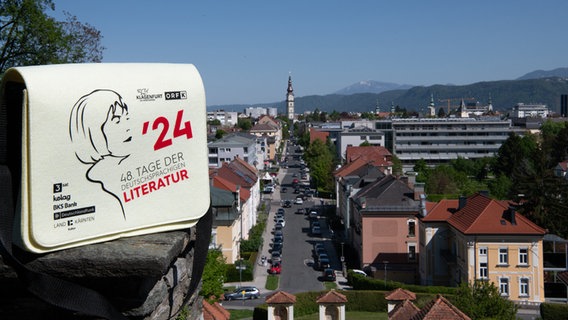 Tasche mit Logo des Bachmannpreises steht auf der Mauer - dahinter die Stadtansicht von Klagenfurt © ORF/Horst L. Ebner Foto: Horst L. Ebner