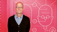 Chris Ware posiert vor einer Wand mit Illustration © Chris Ware/Literaturhaus Hamburg 