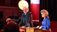 Stefan Gwildis und Annette Frier stehen an zwei Pulten und Lesen © NDR / Maren Janning Foto: Maren Janning