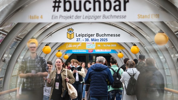 Besucher der Leipziger Buchmesse gehen durch eine Röhre zwischen den Messehallen © Jan Woitas/dpa-Bildfunk Foto: Jan Woitas