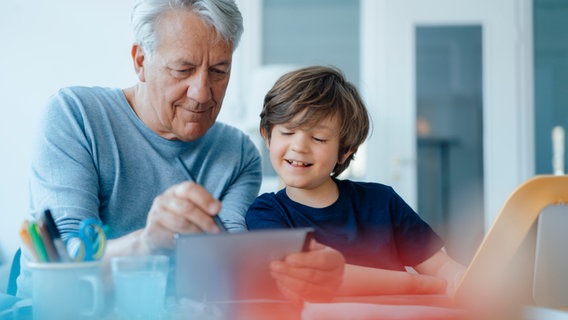 Opa und Enkel lesen auf einem Tablet © picture alliance / Westend61 | Joseffson Foto: Joseffson