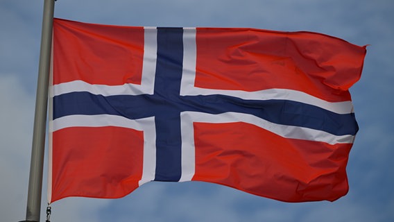 Die norwegische Flagge weht im Wind. © picture alliance / NurPhoto | Artur Widak 