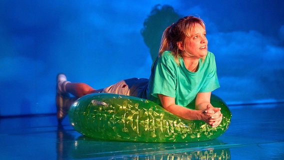 Die Schauspielerin Ellen Neuser als Tilda in einem Schwimmreifen auf der Buhne des Rostocker Ateliertheaters in der Inszenierung von "22 Bahnen". © Thomas Mandt 