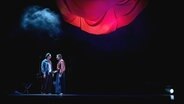 Eine Frau und ein Mann stehen auf einer Theaterbühne und sehen sich an © Schlosstheater Celle/ Marie Liebig 