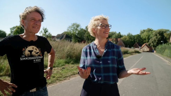 Ein Mann und eine Frau stehen auf einer leeren Straße auf dem Land © NDR Screenshot 